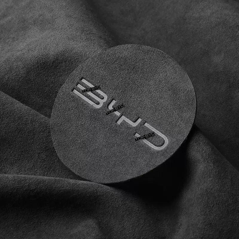 Black suede-textured circular car interior accessory with embossed BYD logo.
