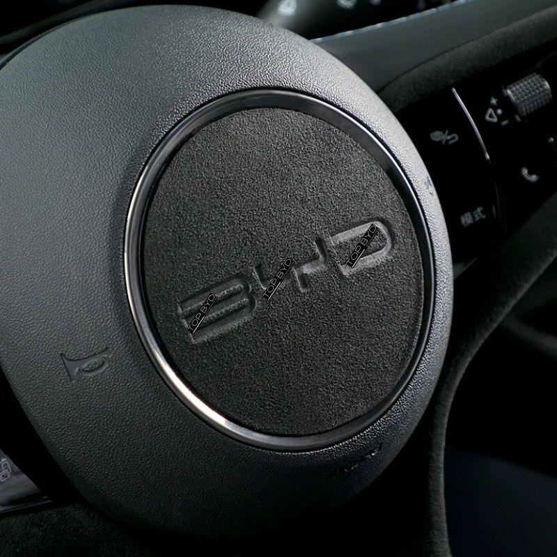 Black Alcantara steering wheel cover with silver trim and BYD logo for premium car interior protection.