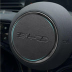 Black textured leather steering wheel cover with a sleek silver trim and subtle blue LED ring.