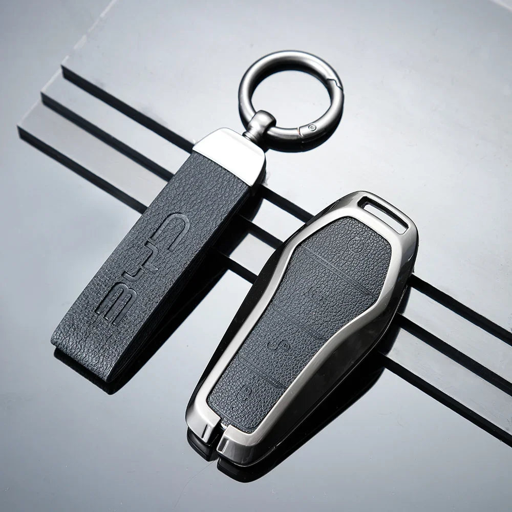 Premium black leather car key fob cover with silver metal trim and embossed BYD logo.