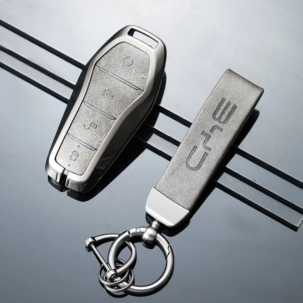 Premium silver metallic car key fob and matching textured leather keychain accessory.