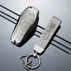 Premium silver metallic car key fob and matching textured leather keychain accessory.