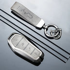 Premium grey leather BYD key fob cover and matching keychain with metallic silver accents.