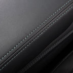 Close-up of premium black leather upholstery with precision blue contrast stitching.