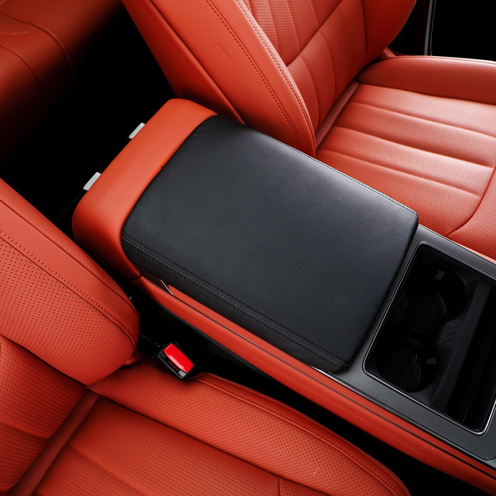 Black leather center console armrest cover for red perforated leather car seats.
