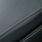 Close-up of high-quality grey leather car interior with precise white contrast stitching.