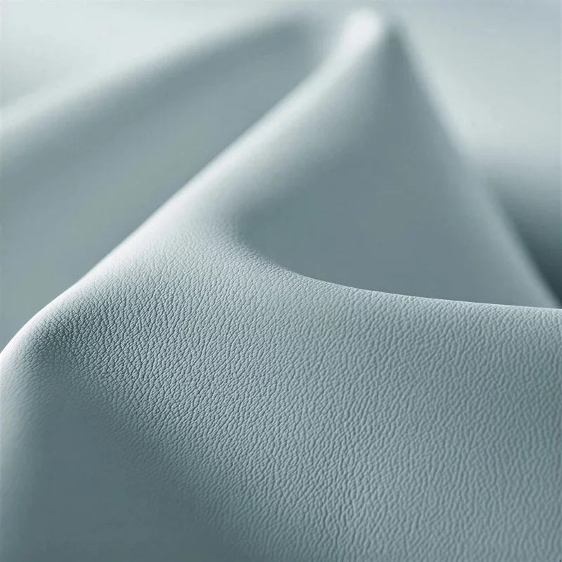 Close-up of premium light grey textured faux leather material for car interior accessories.