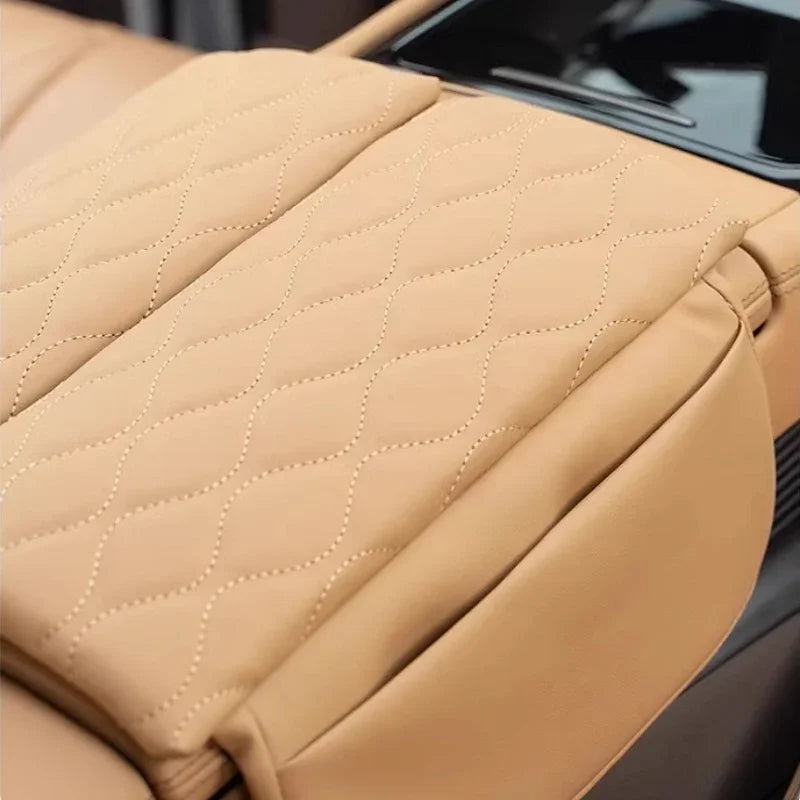 Close-up of tan leather car seat cover with a luxury diamond-quilted stitching pattern.