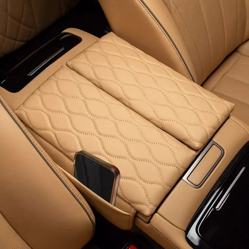Tan quilted leather center console armrest cover with integrated phone holder for car interior.