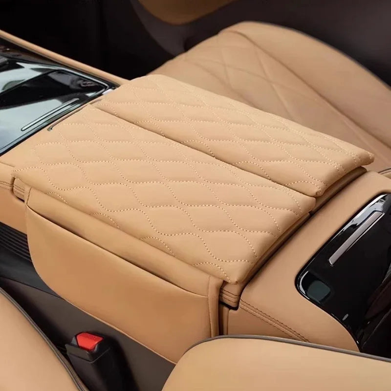 Tan leather center console armrest cover with a luxury diamond quilted stitch pattern.