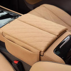 Tan leather center console armrest cover with a luxury diamond quilted stitch pattern.