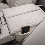 Diamond-stitched cream leather center console armrest cover with integrated phone storage pocket.