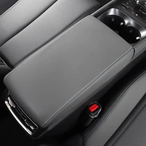 Grey perforated leather center console armrest with blue contrast stitching for BYD models.
