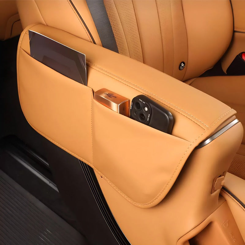 Tan leather car center console organizer with built-in pockets for smartphone and cards.