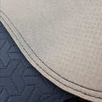 Close-up of grey textured fabric and navy blue quilted leather car interior detailing.