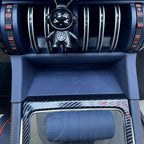 Blue carbon fiber texture center console with wireless charging pad and astronaut ornament.