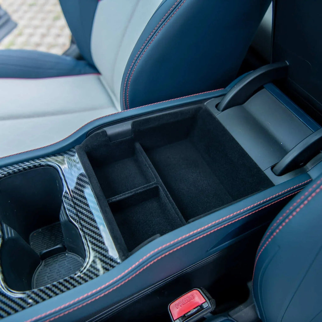 Blue leather center console with carbon fiber trim and red stitching featuring a black felt organizer.