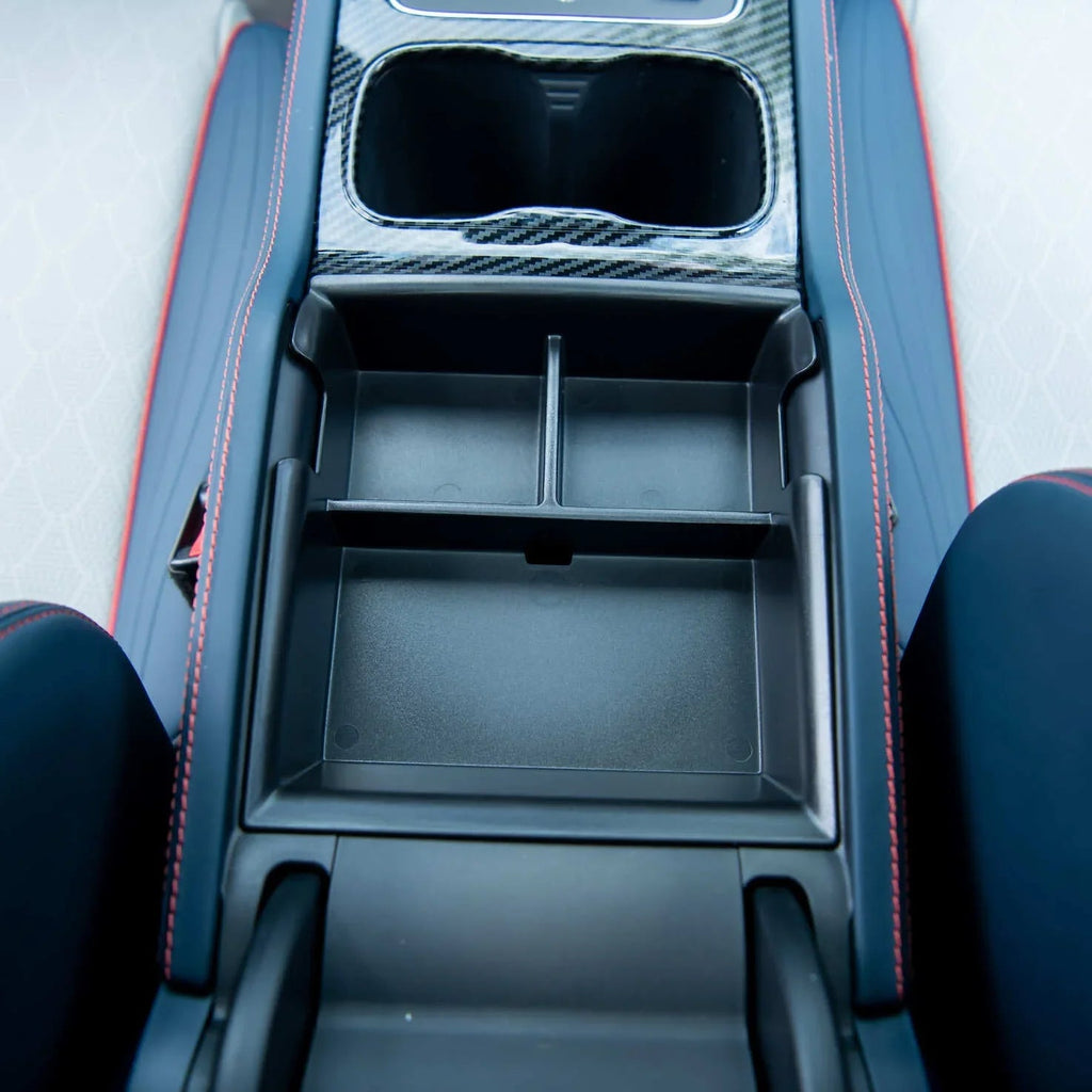 Blue leather car center console with red stitching featuring carbon fiber cup holders and storage tray.