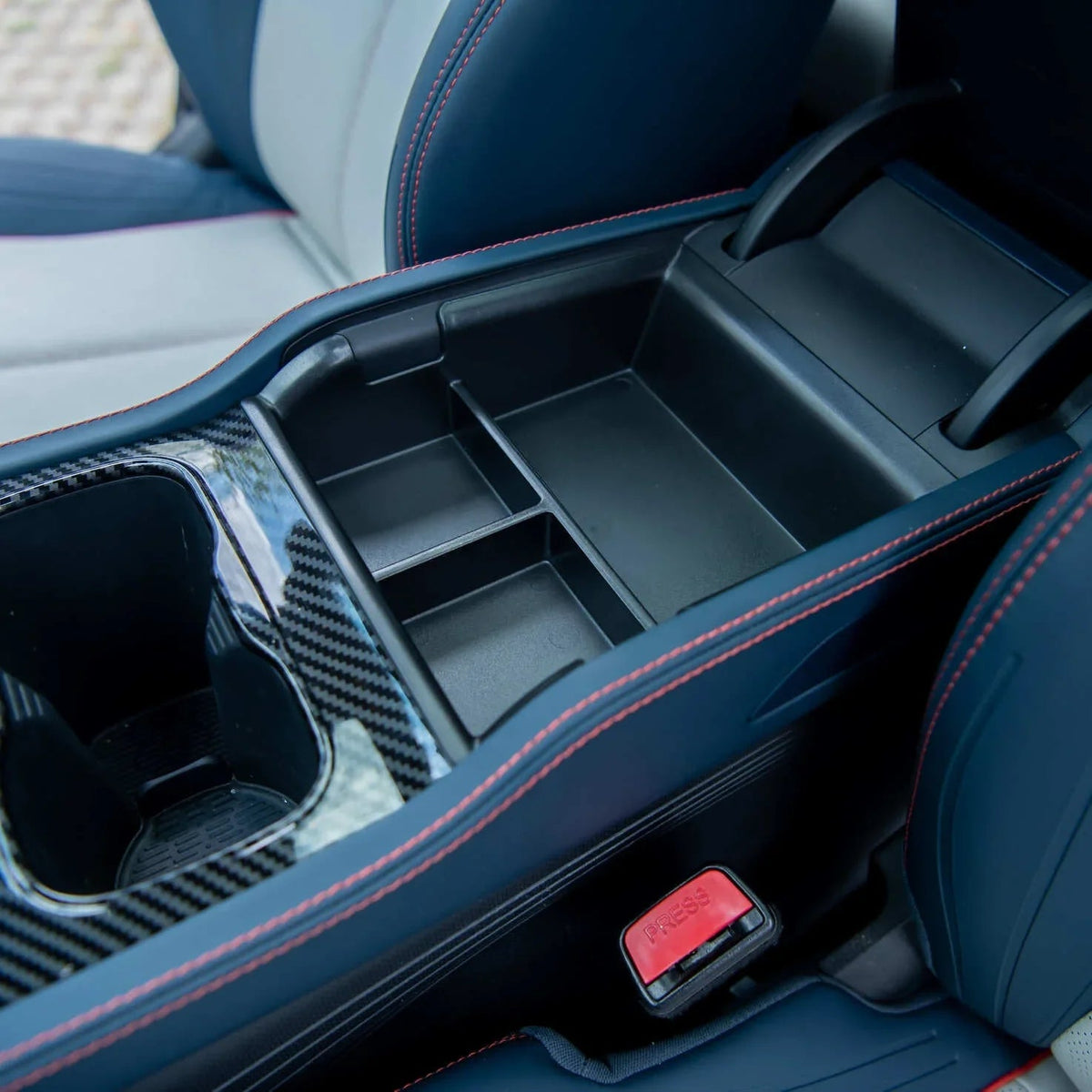 Black carbon fiber patterned center console organizer with red stitching for BYD interior.