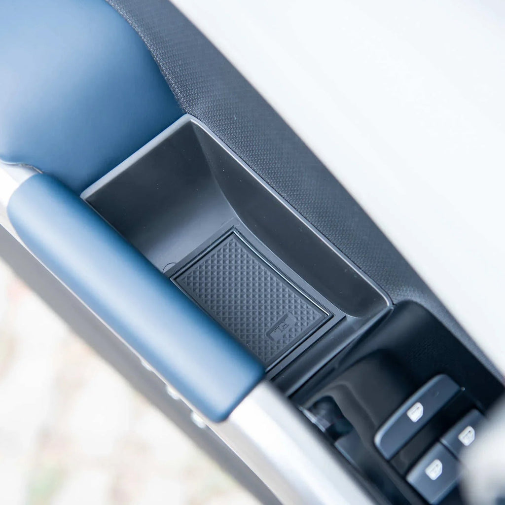 Black textured plastic door pocket storage compartment for BYD car interior.