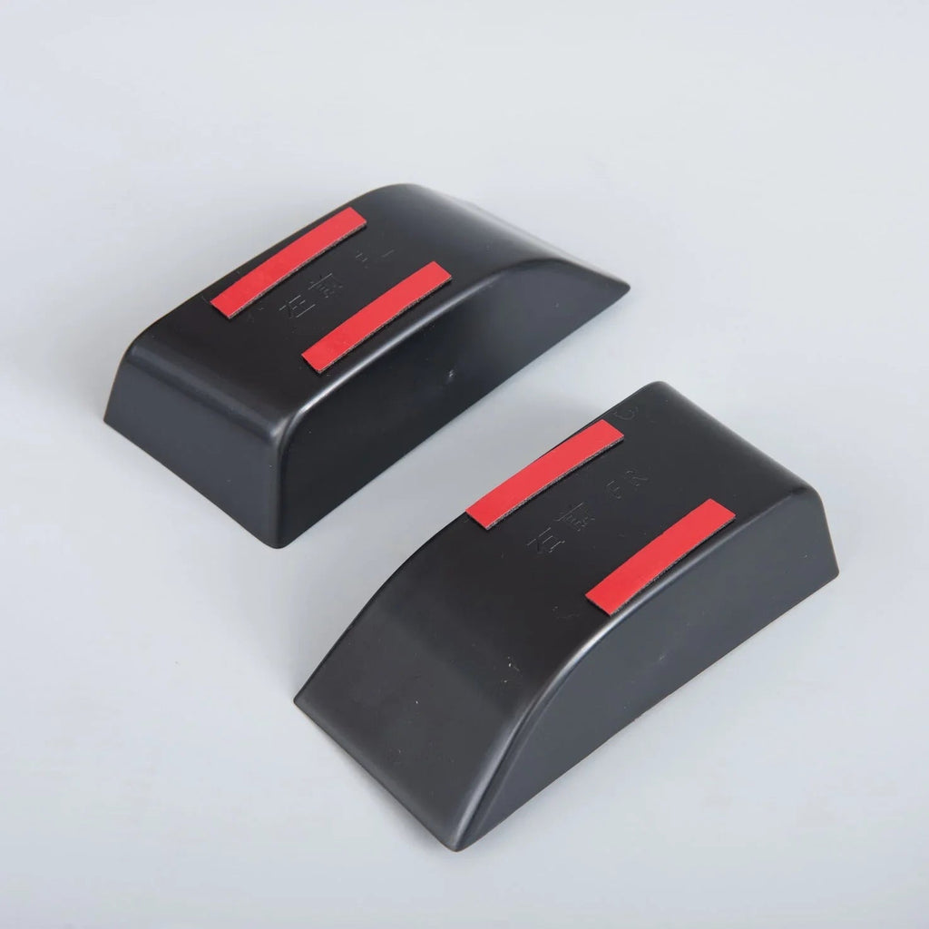Pair of matte black protective bumper guards with distinctive red accent strips.