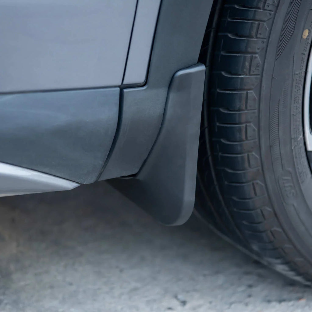 Durable matte black ABS plastic mud flap installed on a grey vehicle wheel arch.
