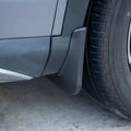 Durable matte black ABS plastic mud flap installed on a grey vehicle wheel arch.