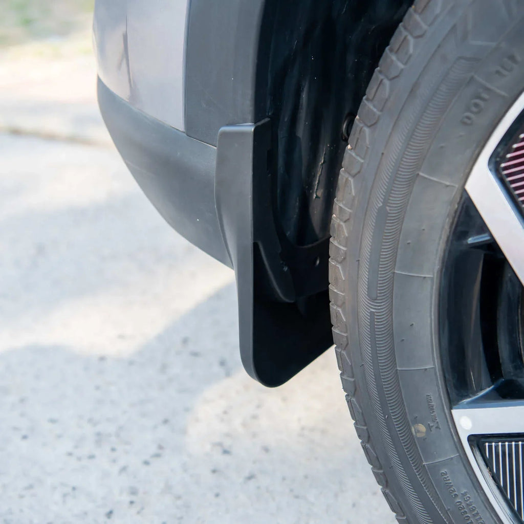 Durable black matte mud flap installed behind the car wheel for superior splash protection.
