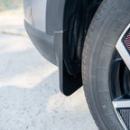 Durable black matte mud flap installed behind the car wheel for superior splash protection.