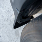 Black durable matte plastic mud flap installed on a vehicle wheel arch for protection.