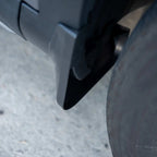 Durable matte black plastic mud flap installed behind the vehicle wheel for splash protection.