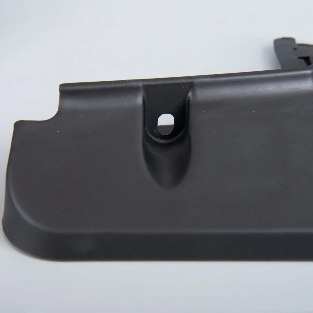 Durable matte black textured plastic automotive trim component with precision mounting hole.