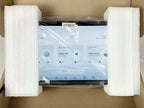 Black touchscreen infotainment system with digital interface, secured in white protective foam packaging.