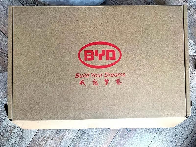 Brown cardboard shipping box featuring the red BYD Build Your Dreams logo.