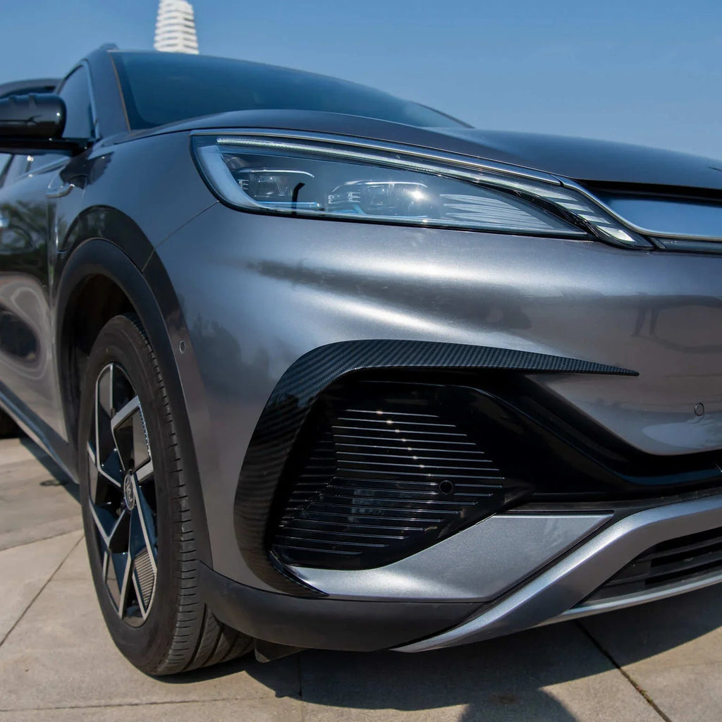 Close-up of a grey car featuring a sleek carbon fiber front bumper trim accent.