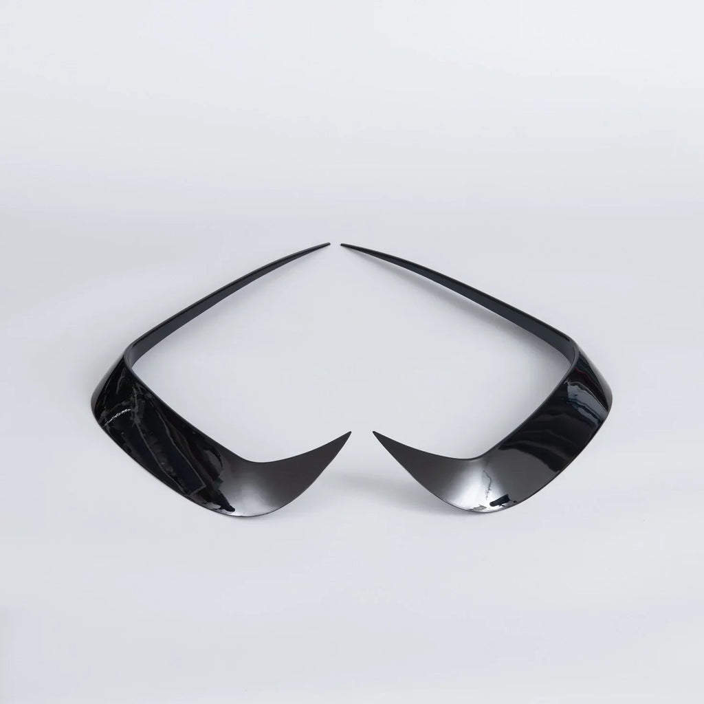 Pair of sleek, glossy black plastic automotive interior trim accents on a white background.