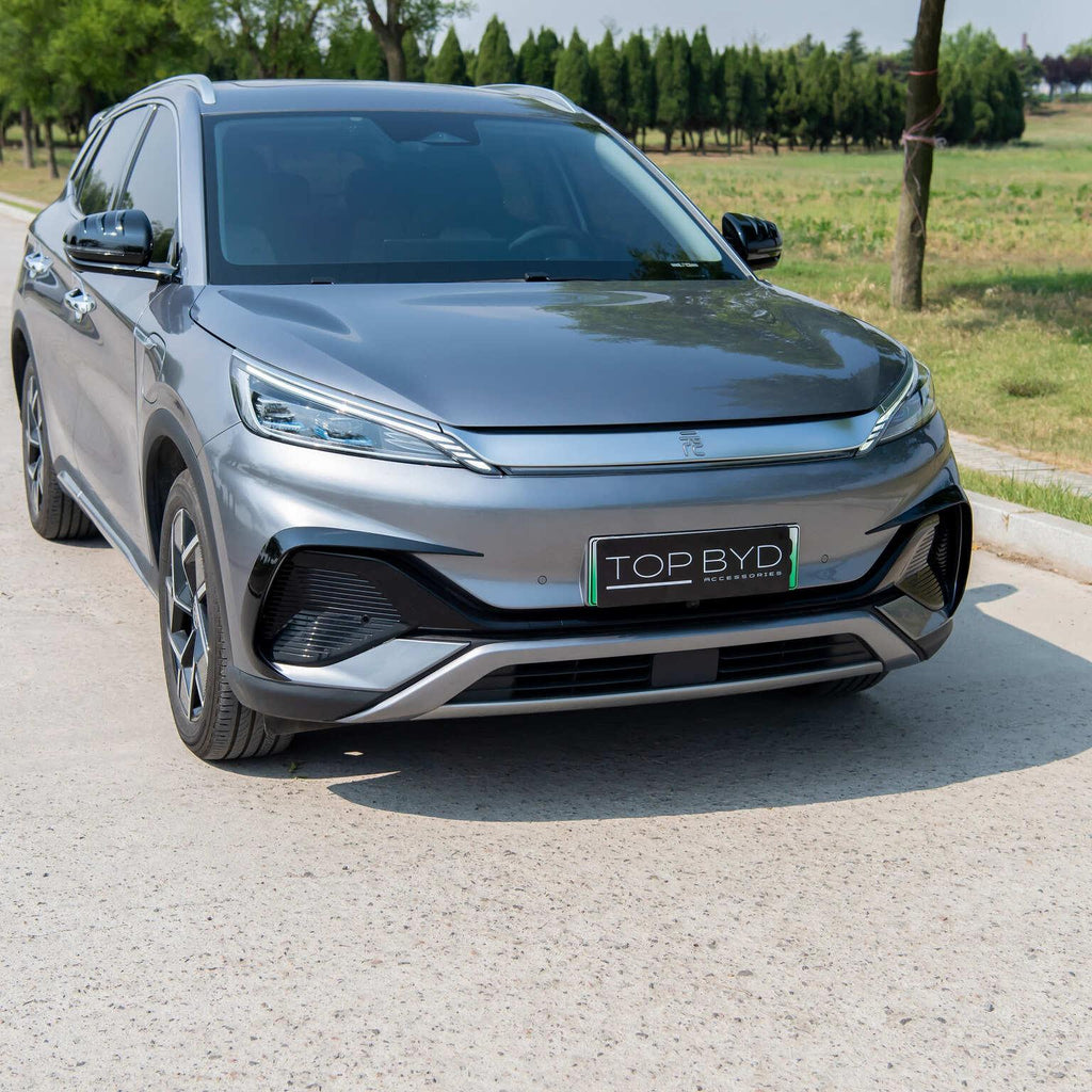 Front view of a sleek, metallic grey BYD electric car parked on a light-colored paved road.