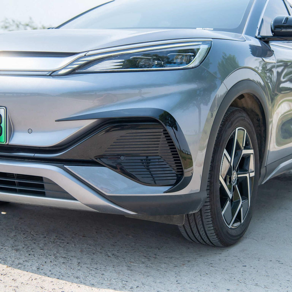 Close-up of a silver BYD electric car featuring sleek LED headlights and black alloy wheels.