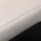 Close-up of premium white leather car seat texture with precise white stitching detail.