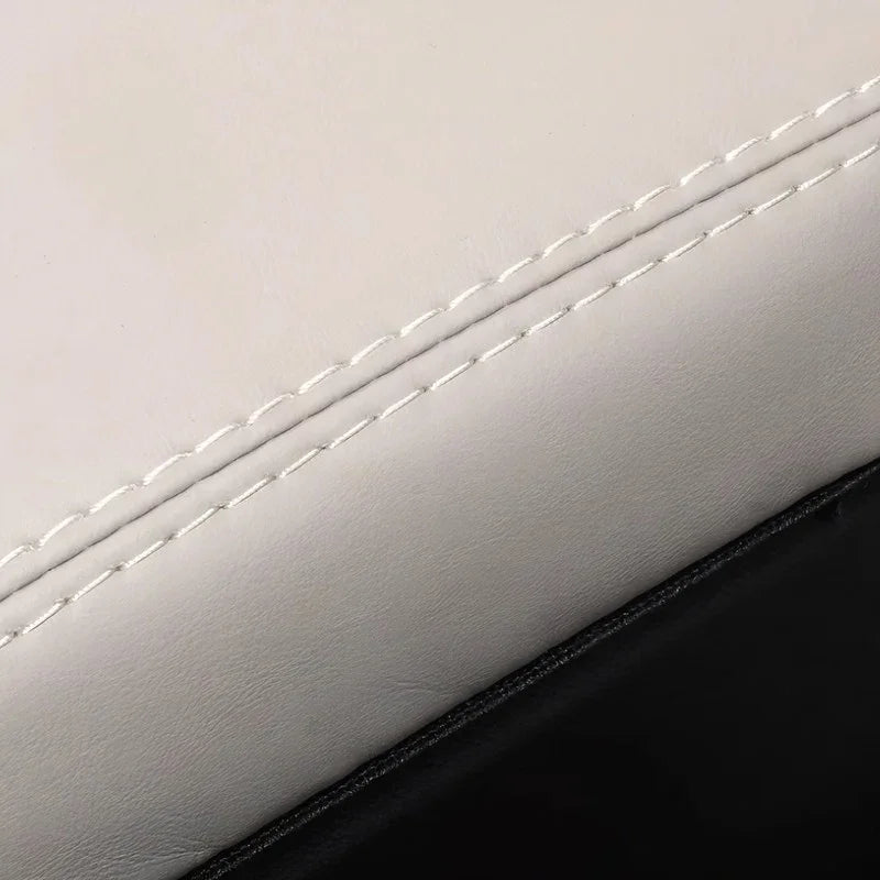Close-up of premium white leather car seat texture with precise white stitching detail.
