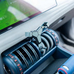 Matte black geometric car air vent phone holder mounted on a sleek blue dashboard vent.