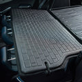 Black heavy-duty rubberized cargo mat protecting the trunk of a vehicle.
