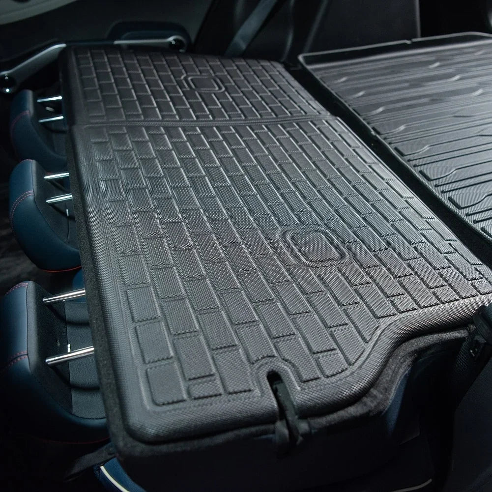 Black heavy-duty rubberized cargo mat protecting the trunk of a vehicle.