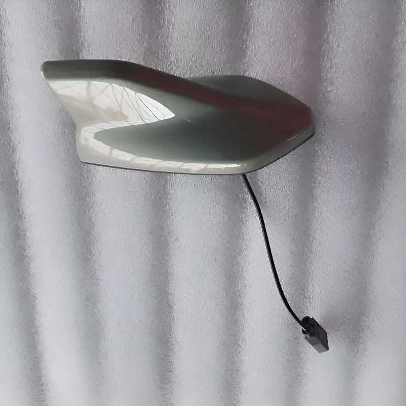 Sleek white shark fin antenna with integrated wiring for seamless car roof installation.