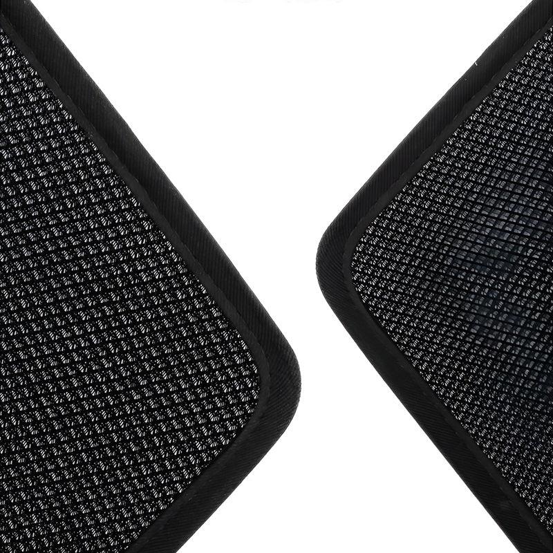 Close-up of black textured synthetic material car floor mats with reinforced edges.