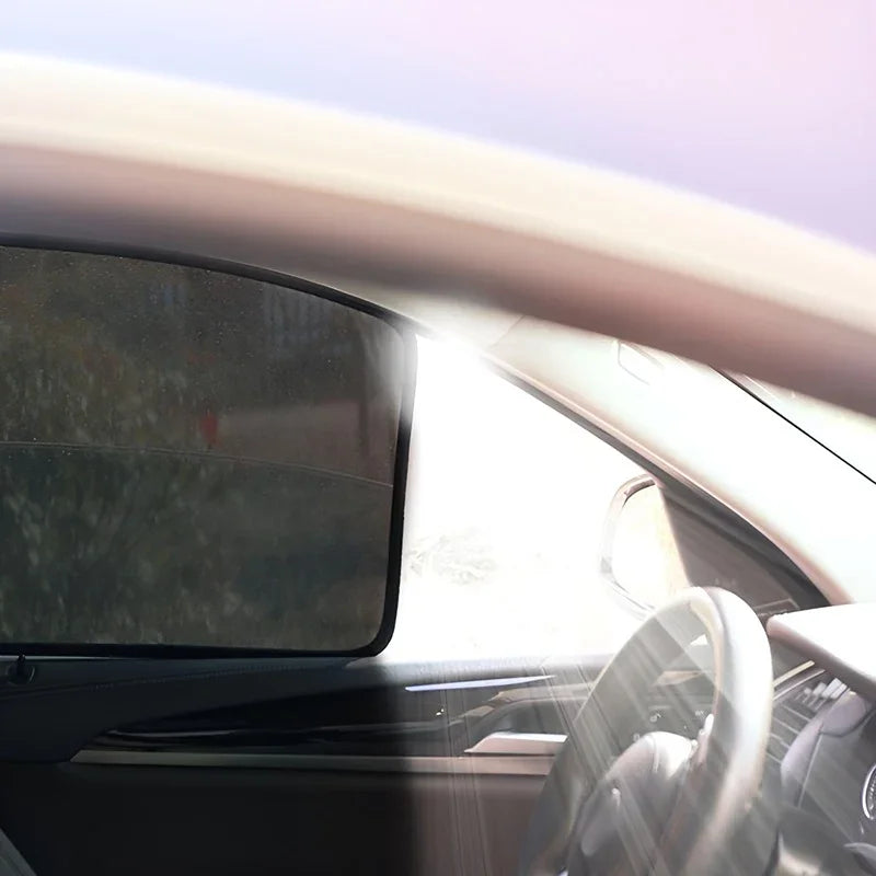 Black mesh sunshade installed on a car side window for heat and UV protection.