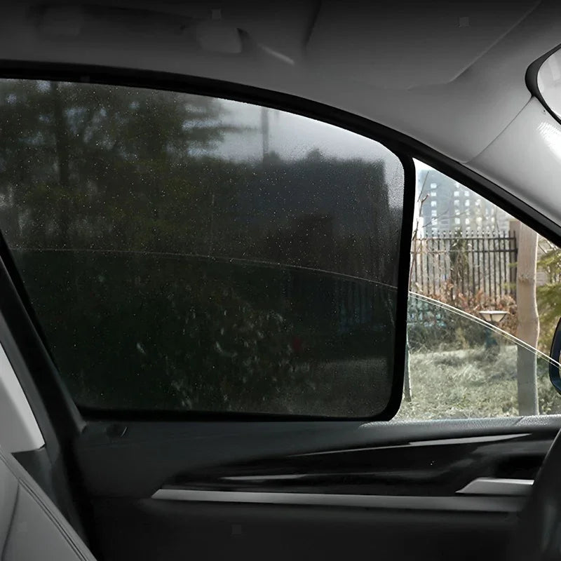 Black mesh car window sunshade installed on a vehicle side window for privacy and shade.