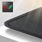 Close-up of a black textured carbon fiber car mat with a durable stitched edge.