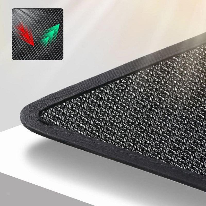 Close-up of a black textured carbon fiber car mat with a durable stitched edge.