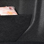 A pink packaged item stored in a black felt car seat organizer pocket.
